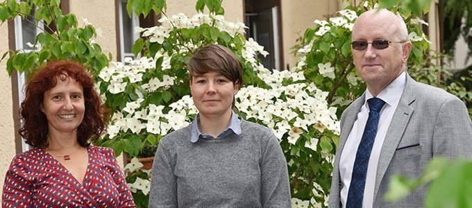 Auf dem Bild stehen links Dorothee G??ner (Koordinatorin), in der Mitte Ariane Kehr (konzeptionelle Mitarbeit) und rechts Prof. Dr. David J. Green (Diversit?tsbeauftragter) vor einem wei?-blhendem Strauch.